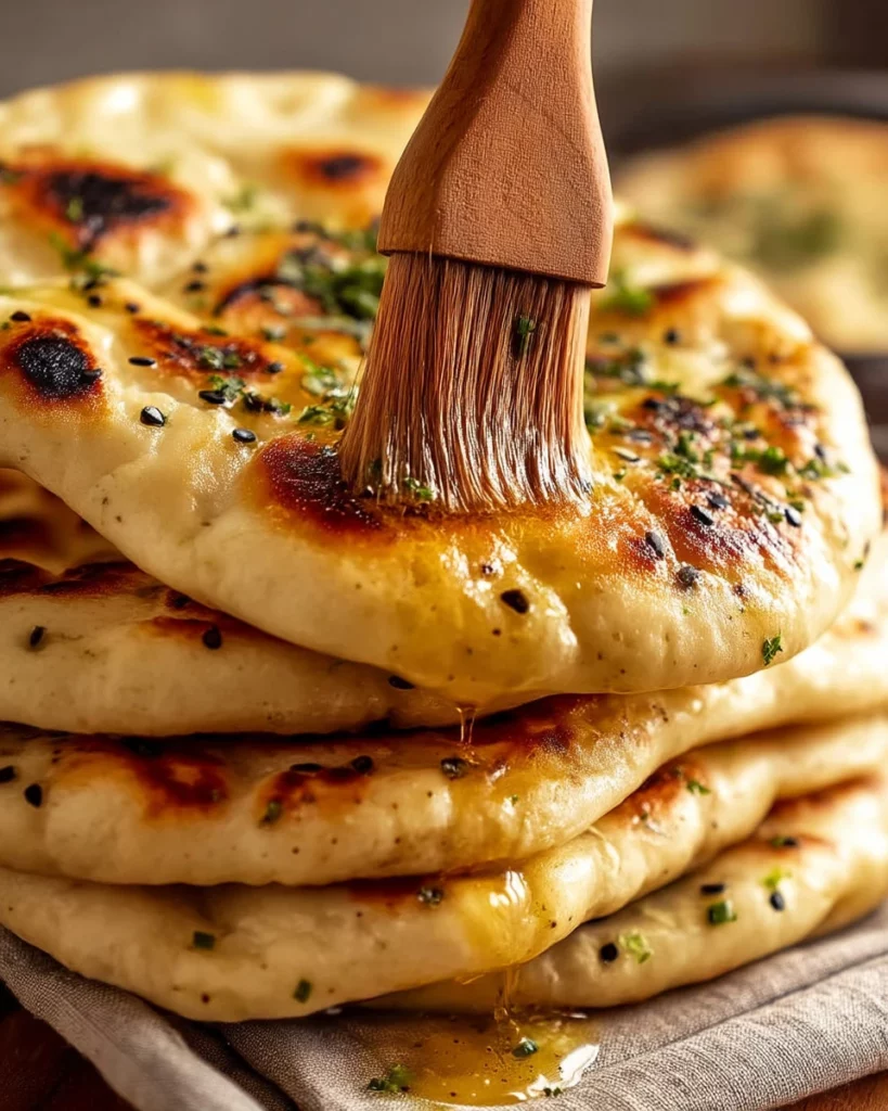 Freshly baked fluffy and bubbly naan bread, golden brown and delicious.