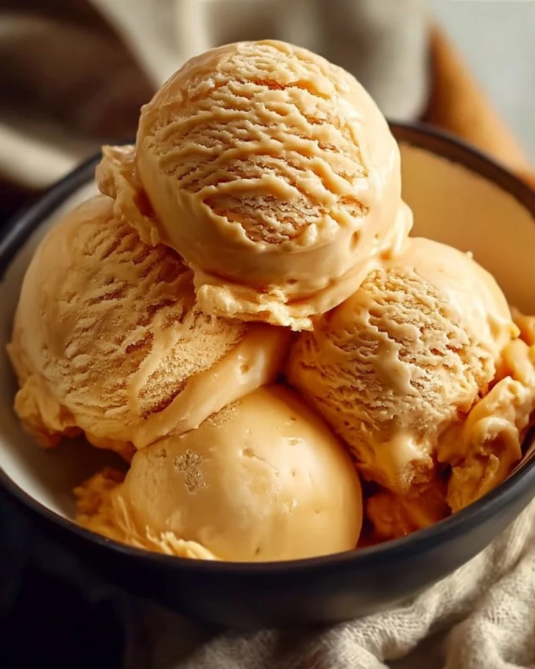 Bowl of homemade creamy caramel ice cream topped with caramel drizzle